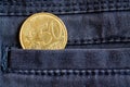 Euro coin with a denomination of 50 euro cents in the pocket of dark blue denim jeans Royalty Free Stock Photo