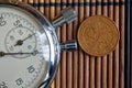 Euro coin with a denomination of five euro cents and stopwatch on wooden table - back side Royalty Free Stock Photo