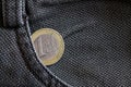 Euro coin with a denomination of one euro in the pocket of worn gray denim jeans Royalty Free Stock Photo