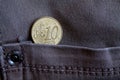 Euro coin with a denomination of 10 euro cent in the pocket of worn gray denim jeans Royalty Free Stock Photo