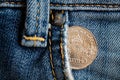 Euro coin with a denomination of twenty euro cents in the pocket of old worn denim jeans Royalty Free Stock Photo