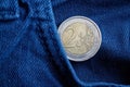 Euro coin with a denomination of 2 euro in the pocket of old vintage blue denim jeans Royalty Free Stock Photo