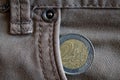 Euro coin with a denomination of two euro in the pocket of worn gray denim jeans Royalty Free Stock Photo