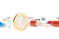 Euro coin in front of medical pills Royalty Free Stock Photo