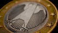 1 euro coin issued in Germany close-up. Obverse with the Federal Eagle. Dark dramatic economic background or backdrop. European