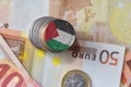 Euro coin with national flag of palestine on the euro money banknotes background.