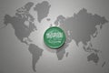 Euro coin with national flag of saudi arabia on the gray world map background.3d illustration