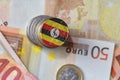 Euro coin with national flag of uganda on the euro money banknotes background.