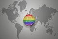 Euro coin with rainbow gay flag of on the gray world map background.3d illustration