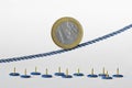 Euro coin on rope over push pins - Concept of upward trend of euro currency and euro currency risk Royalty Free Stock Photo