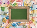 Euro coins, banknotes background, green chalkboard Royalty Free Stock Photo