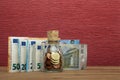 Euro coins and bill on the burgundy red background in a money box Royalty Free Stock Photo