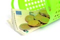 Euro coins and bills in donation or consumer green basket