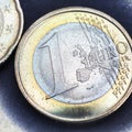 Euro coins. The focus is on the inscription with the name of the Eurozone currency on the 1 euro coin. Closeup. Square