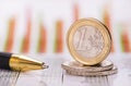 Euro coins stacked over data of exchange market Royalty Free Stock Photo