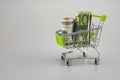 Euro and dollar banknotes in rolls with supermarket trolley on gray background. Royalty Free Stock Photo