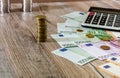 Euro, dollars, cents and calculator spread out on a wooden background Royalty Free Stock Photo