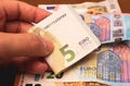 Euro, European Union Currency. A man holding a five euro bill. Close-up photo. Royalty Free Stock Photo