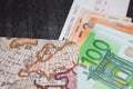 Euro Money, Airplane ticket and map. Eurobanknotes with boarding pass and map, on black wooden background. Royalty Free Stock Photo