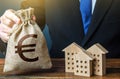 Euro money bags and residential buildings figures. Investments in real estate and construction industry. Taxes. Bank offer of