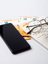 Euro money banknotes, keyboard, smartphone and glasses, online banking, business, student loan concept