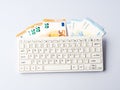 Euro money banknotes under keyboard, online banking, sale of digital info products concept