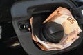Euro money in car fuel tank opening. Royalty Free Stock Photo