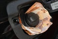 Euro money in car fuel tank opening. Royalty Free Stock Photo