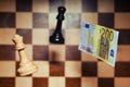 Euro money and a chessboard with chess pieces. Concept of problems of financial game, money and European economy Royalty Free Stock Photo