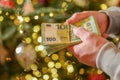 euro money in hands on a Christmas trees background.Christmas and New Year expenses. Spending on gifts and decor Royalty Free Stock Photo