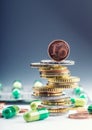 Euro money and medicaments. Euro coins and pills. Coins stacked on each other in different positions and freely pills around