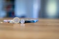 Euro notes and standing coins on a wooden table. Blurry, out of focus background. Bokeh.