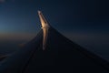 View through an airplane window onto the wing of an Ryanair Boeing 737-800 airplane with winglets in flight during sunset