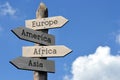 Europe, America, Africa, Asia - wooden signpost with four arrows