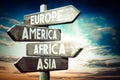 Europe, America, Africa, Asia - wooden signpost, roadsign with four arrows