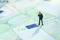 Europe economy, financial, investment or impact of brexit concept, miniature businessman figurine standing and looking at Euro si