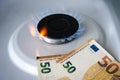 europe euro is burning in the fire. concept the rise in price of gas in euro. a bill burns in a fire on a gas stove