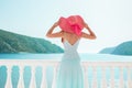 Europe Greece travel vacation. Woman looking at sea view. Elegant young lady living fancy jetset lifestyle wearing dress on holida