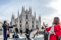 Italy. Milan. Cathedral, Duomo di Milano. Tourists playing with pigeons Royalty Free Stock Photo