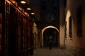 Europe night backstreet town urban view arch alley dangerous place with unknown person in black coat back to camera criminal