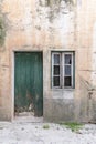 An old green wooden door in a stucco house