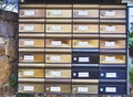 European metallic mailboxes on a stone wall.