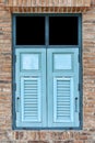 Antique blue wooden shutters window and brown stone brick wall Royalty Free Stock Photo