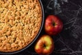 European apple pie with topping crumbles in springform pan on right side and blank copy space on black marbel background to left s