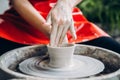 European artist girl making clay dishes on potter wheel, happy and smiling. Concept of love for work, craft Royalty Free Stock Photo