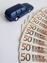 european banknotes and figure of a car in dark blue