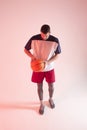 European basketball player holding ball in studio