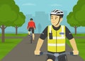 European bicycle patrol. Police officer riding bike on bike path in city park. Royalty Free Stock Photo