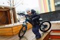 European boy dressed in a winter jacket is tired of riding a bicycle Royalty Free Stock Photo