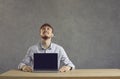 European cheerful man shows a laptop with a black screen on the table Royalty Free Stock Photo